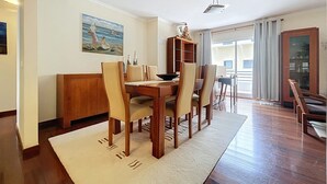 Un comedor con mesa de madera, sillas y aparador.
