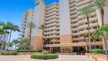 A multi-story hotel with a central courtyard, palm trees, and a fountain.