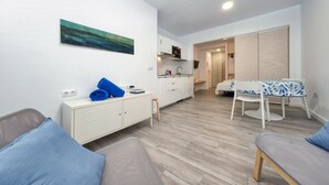 A modern, compact living space with a kitchenette, a dining area, and a bedroom. - Studio el Greco next to Reducto beach (Arrecife)