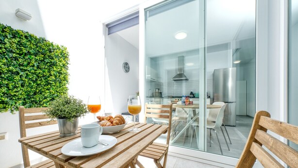 A modern kitchen with a glass door leading to a dining area.