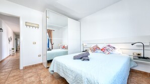 Een slaapkamer met een groot bed, een kledingkast en een bordje met de tekst 'HOME'.