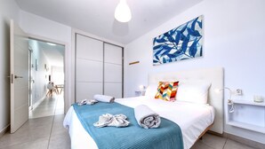 Ein Hotelzimmer mit Bett, großem Fenster, Bad und Flur.