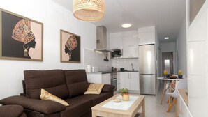 A modern living room with a brown sofa, a wooden coffee table, and two framed artworks.
