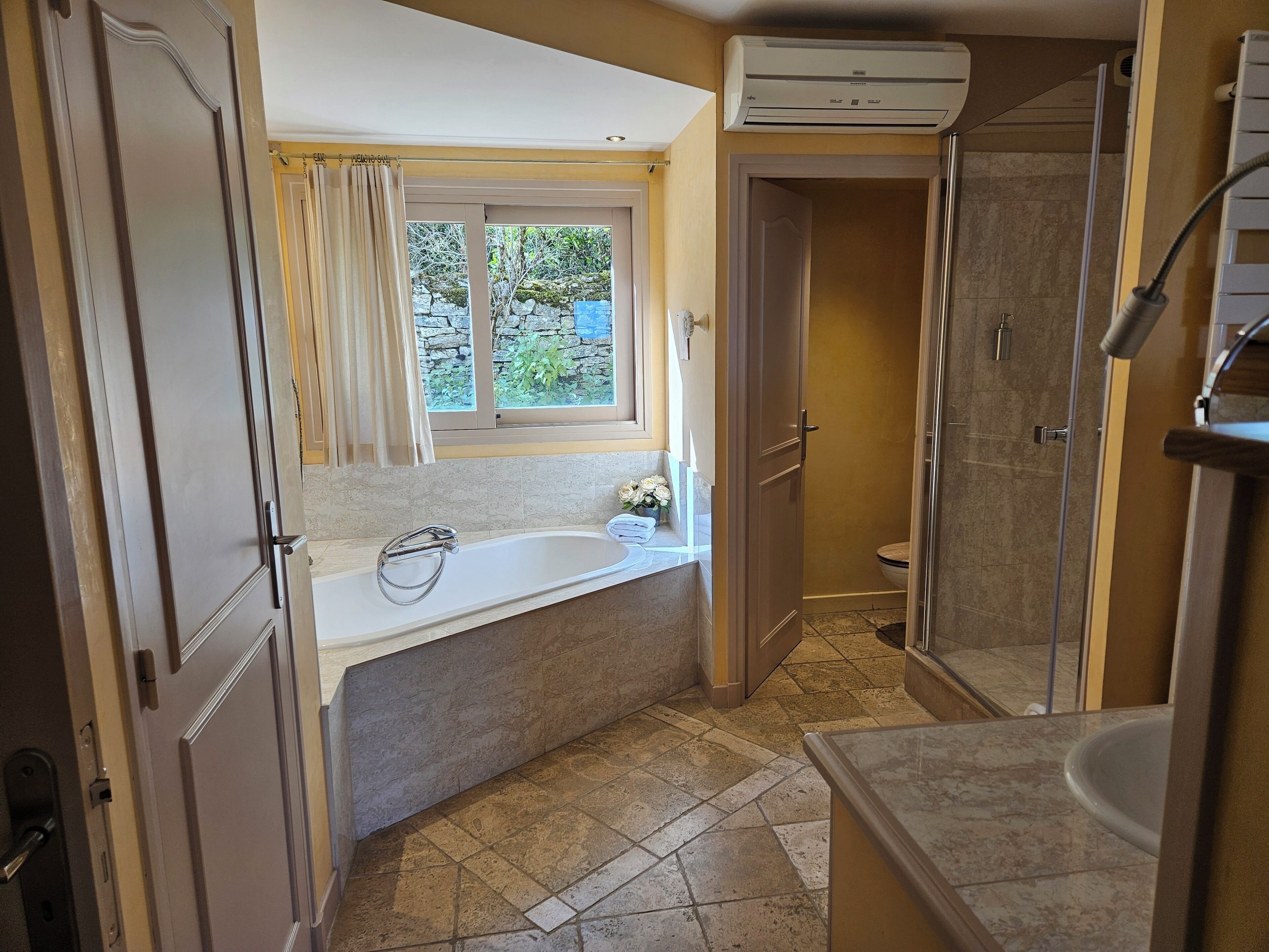 A bathroom with a bathtub, shower, and toilet.