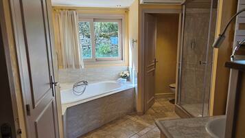 A bathroom with a bathtub, shower, and toilet.