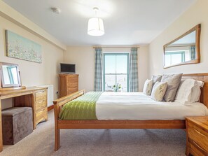 A bedroom with a bed, bedside tables, a desk, a television, and a window with curtains. - 3 bedroom accommodation in Arnside and Silverdale (Arnside and Silverdale)