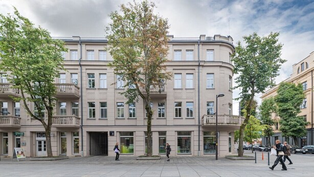 A multi-story building with a flat facade, balconies, and a ground-level entrance.