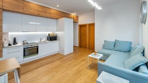 Un appartement moderne comprenant une cuisine, un coin repas et un salon avec un canapé.