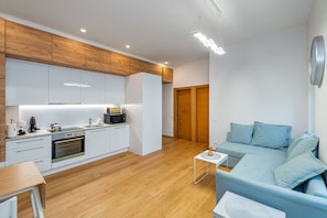 A modern apartment with a kitchen, dining area, and a living room with a sofa.