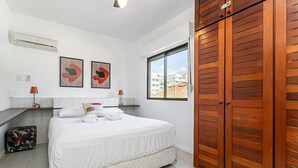 A bedroom with a bed, a wardrobe, a window, and artwork on the wall. - 200m from Beach | Bbq Grill | Swimming Pool #IA29 (Florianópolis)