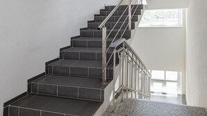 A staircase with a metal railing, leading to a higher floor.