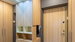 A walk-in closet with wooden cabinets, built-in shelves, and a metal rack.