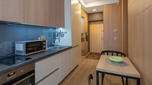 A compact kitchen with a microwave, sink, and dining area.