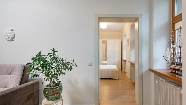En hall med en växt, en säng och en modell av ett skepp.