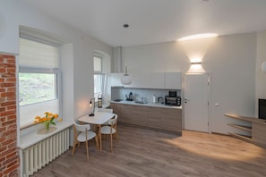 Een moderne keuken met een eethoek, een inbouwoven en een televisiemeubel.