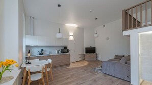 Un appartement moderne comprenant une cuisine, un coin repas et un salon.