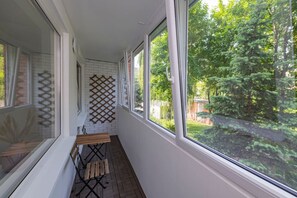 Un couloir étroit doté de grandes fenêtres, d’un banc en bois et d’un mur en treillis.