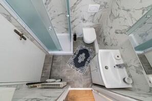 Ein Badezimmer mit Dusche, Toilette und Badewanne.