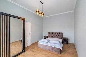 Ett sovrum med en säng, sängbord, en garderob och en hängande lampa.