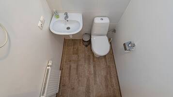 A bathroom with a sink, toilet, and radiator.