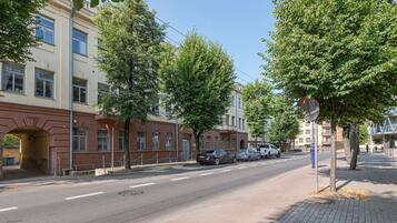 Een straat met gebouwen, bomen en geparkeerde auto's.