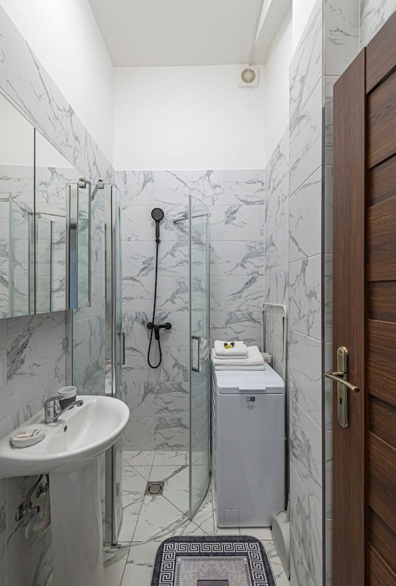 Une salle de bain avec une douche à parois de verre, un lavabo et des toilettes.