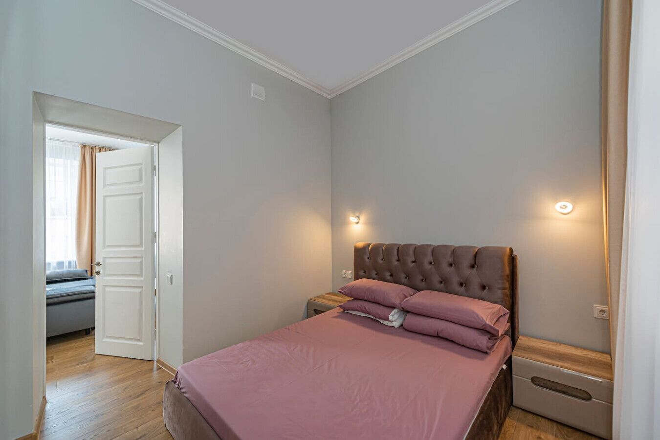 Une chambre à coucher avec un lit, une table de chevet et une lampe fixée au mur.