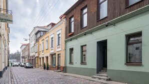 A cobblestone street lined with multi-story buildings, some with visible balconies and windows. - Downtown delight studio by Polo Apartments (Kaunas)