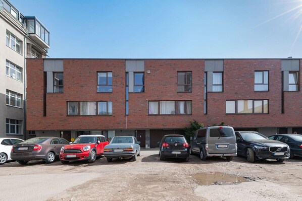 A multi-story building with a parking lot in front.