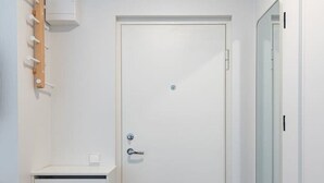 A white door with a handle, a small light above it, and a mat at the entrance. - Studio ap Sea by Polo Apartments (Kaunas)