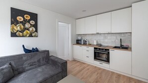 A modern kitchen with white cabinets, a wooden countertop, and a built-in oven.