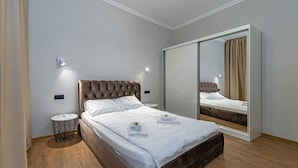 A bedroom with a bed, bedside table, mirror, and wardrobe. - The Comfort Ap 3 by Polo Apartments (Kaunas)