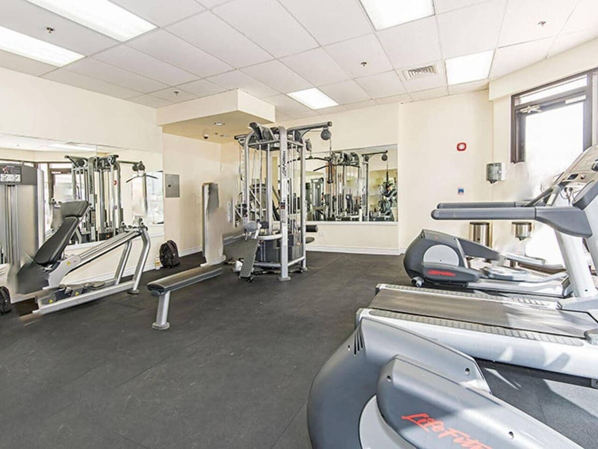 Ein Fitnessstudio mit Laufbändern, Crosstrainern und Krafttrainingsgeräten.