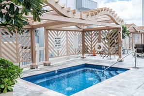 Un espace piscine équipé d’un poste de surveillance pour les sauveteurs, d’un panneau indiquant le numéro de la piscine et d’un panneau d’avertissement.
