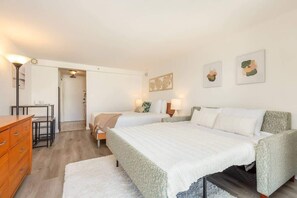 Une chambre avec deux lits, un bureau et une commode.