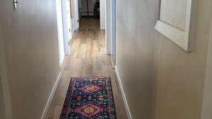 A hallway with a patterned rug, wooden flooring, and white walls. - Downtown walkable to restaurants, bars public transportation and the waterfront. (Charlottetown)