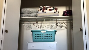 A closet with a teal laundry basket, white drawers, and hanging clothes. - Downtown walkable to restaurants, bars public transportation and the waterfront. (Charlottetown)
