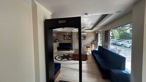 A hotel lobby with a reception desk, seating area, and a view of parked cars outside. - HOTEL SINGH CONTINENTAL (New Delhi)