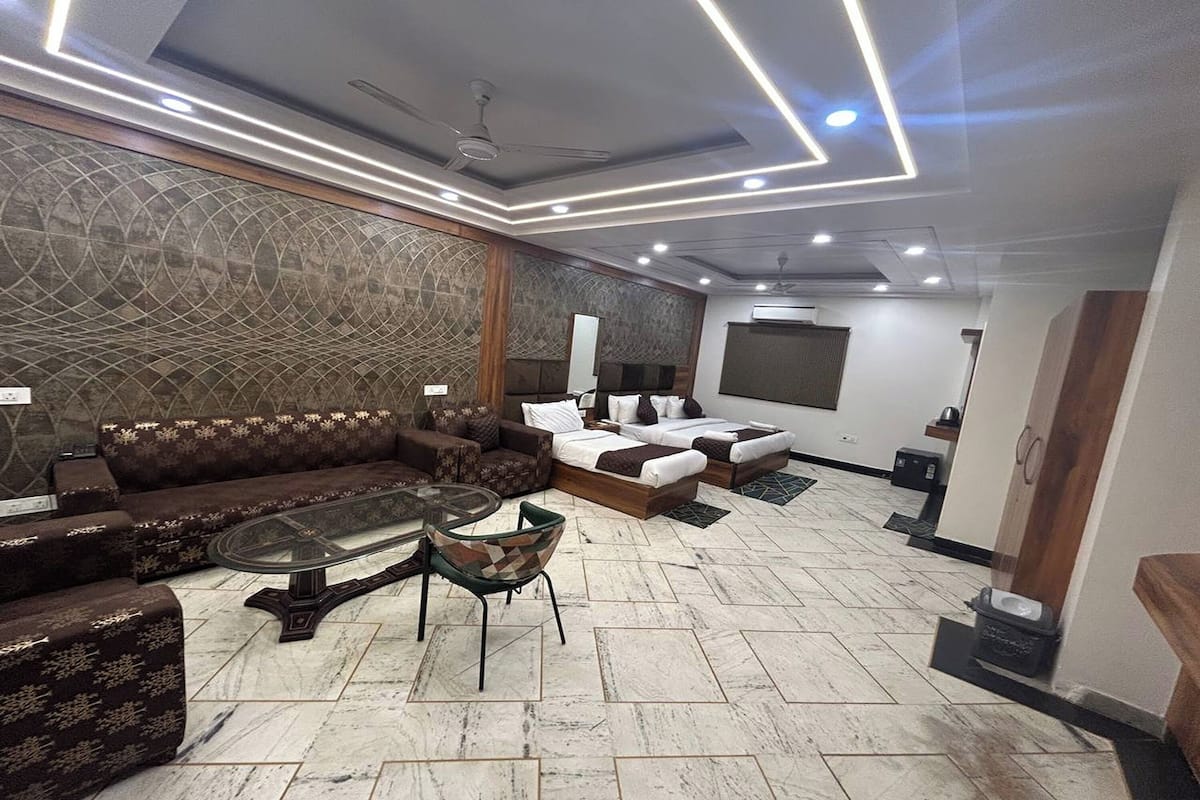 Una sala de estar moderna con un sofá seccional, una mesa de centro de vidrio y un ventilador de techo.