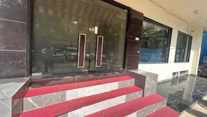 A building entrance with a closed glass door, red carpeted steps, and a tiled floor. - HOTEL SINGH CONTINENTAL (New Delhi)
