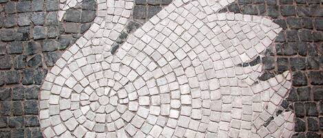 Un cygne en mosaïque sur une surface pavée.
