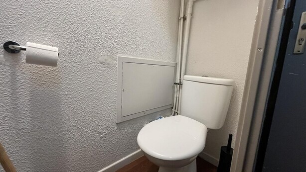 A small bathroom with a toilet, a white wall, and a door. - Ski-in/ski-out & foot of the slopes, 3rd floor, balcony, tv, ski locker, 30m², La Plagne (La Plagne)