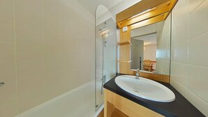 A modern bathroom with a glass shower enclosure, a white sink, and a wooden vanity. - Ski-in/ski-out & foot of the slopes, 3rd floor, balcony, tv, ski locker, 30m², La Plagne (La Plagne)