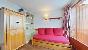 A bedroom with a wooden bed, a wardrobe, and a shelf unit. - Ski-in/ski-out & foot of the slopes, 3rd floor, balcony, tv, ski locker, 30m², La Plagne (La Plagne)