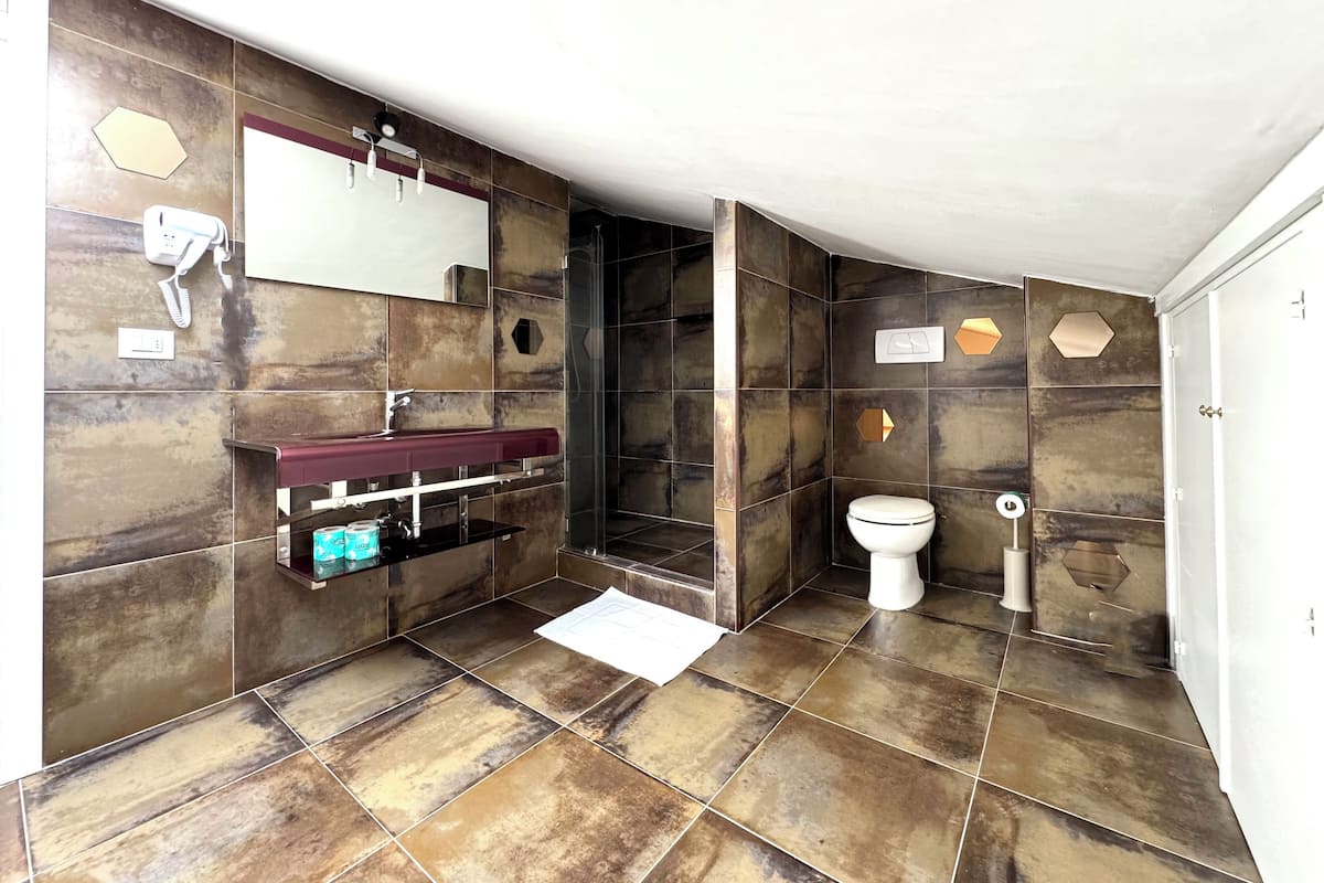 Une salle de bain moderne avec un sol en marbre, un lavabo intégré, une douche en verre et des toilettes.