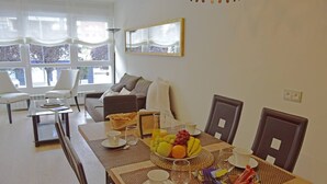 A dining area with a table set for breakfast, including fruits, pastries, and coffee. - Spacious apartment 9 min from the beach (Gijon)