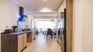 A modern kitchen with a marble countertop, wooden cabinets, and a built-in stove. - Spacious apartment 9 min from the beach (Gijon)