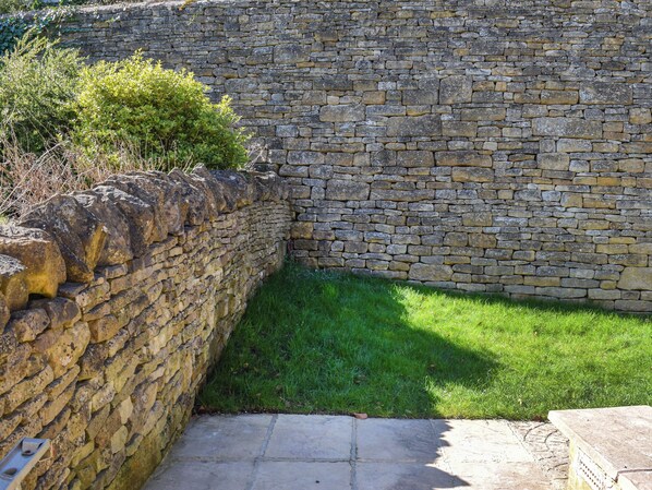 A stone wall with a grassy area in front.