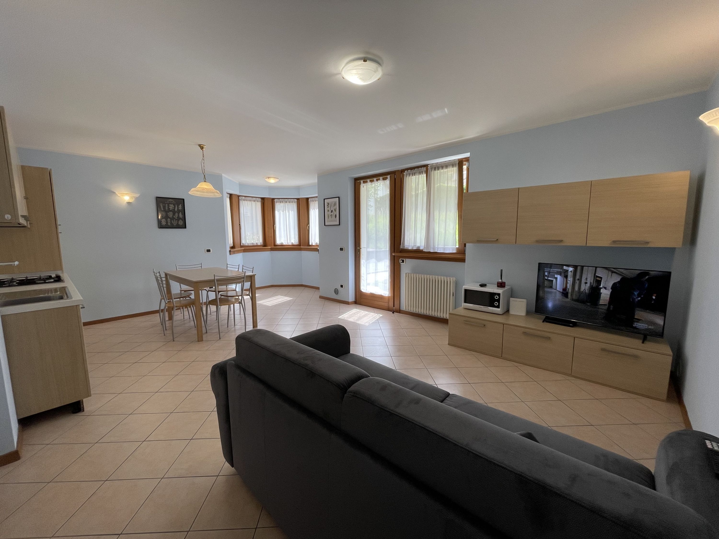 A spacious living area with a sofa, dining table, and kitchen area.