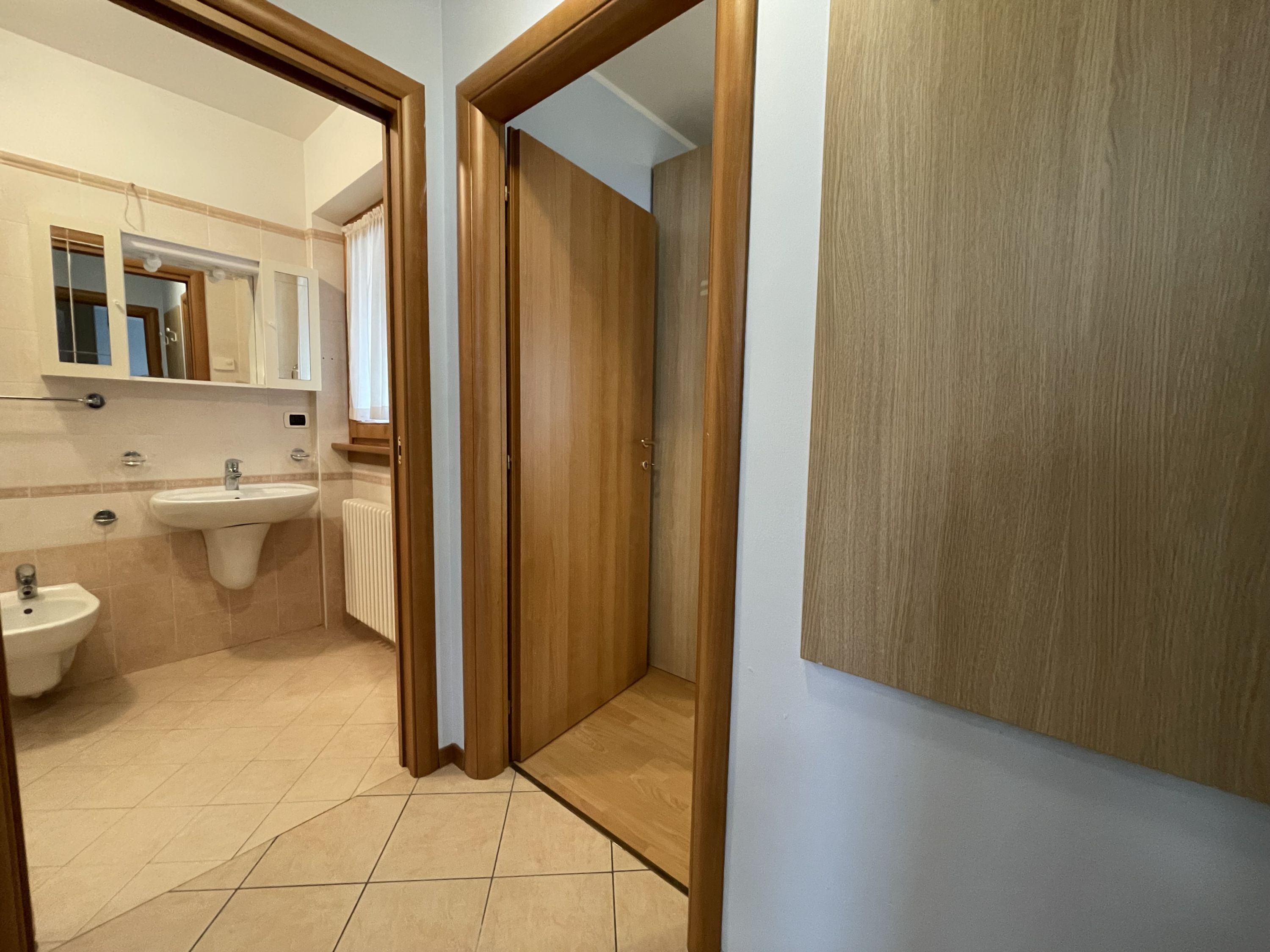 Un bagno con lavandino, specchio e water.